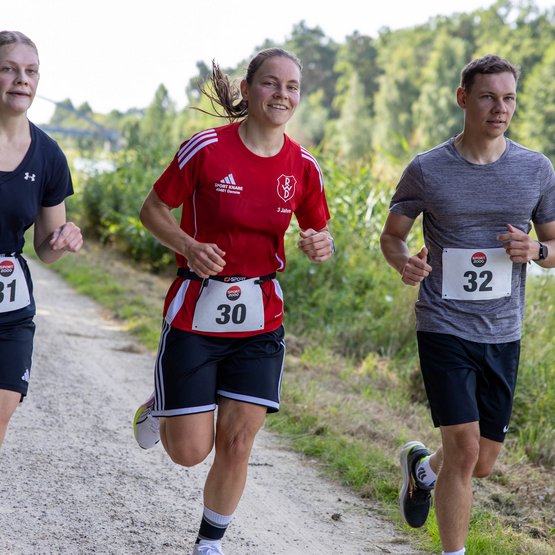 Zum Abschluss geht es für 5 Kilometer auf die Laufstrecke. Läufer auf der Strecke am Kanal.