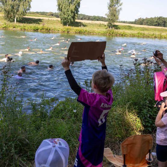 Vom Ufer aus feuern die Fans die Schwimmerinnen und Schwimmer an. Vom Ufer aus feuern die Fans die Schwimmerinnen und Schwimmer an.