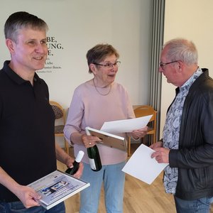 Christian Speer (rechts) überreicht Markus Holtmeyer und Irmgard Weiß Präsente.