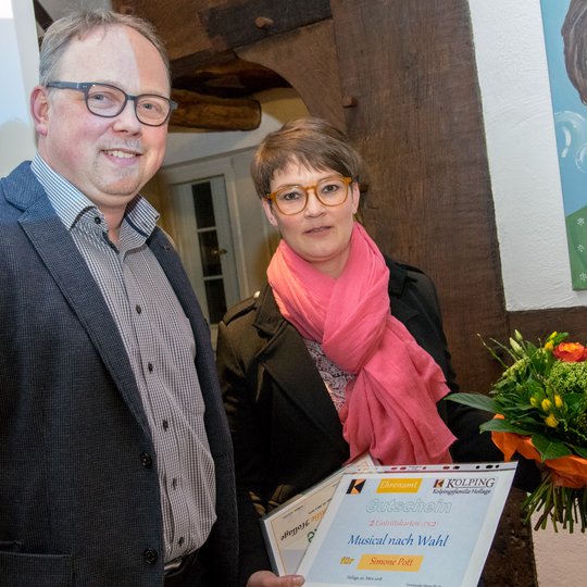 Heiner Placke überreicht Simone Pott Blumen und einen Gutschein für einen Musicalbesuch.